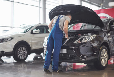 Picture showing muscular car service worker repairing vehicle Picture showing muscular car service worker repairing vehicle.
