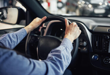 auto business, car sale, consumerism and people concept - happy woman taking car key from dealer in auto show or salon.