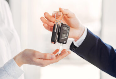 Woman buying the car. Lady in a car salon. Manager with a client