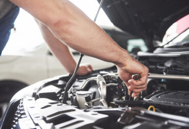 Close up hands of unrecognizable mechanic doing car service and maintenance.