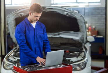 Mechanic using laptop in repair garage